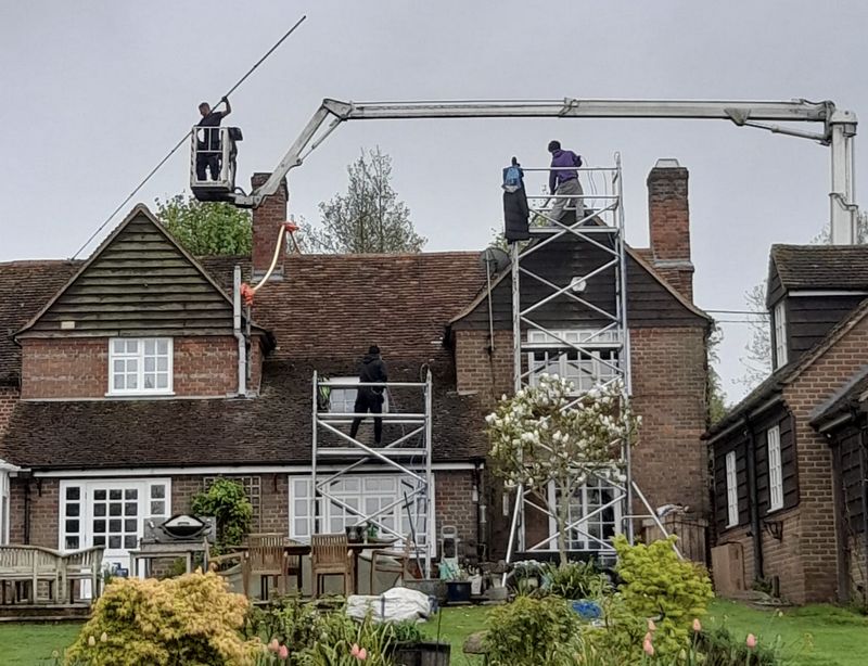 The Moss Cleaners using cherry picker and scaffolding to clean roof safely and professionally in Salisbury, Wiltshire